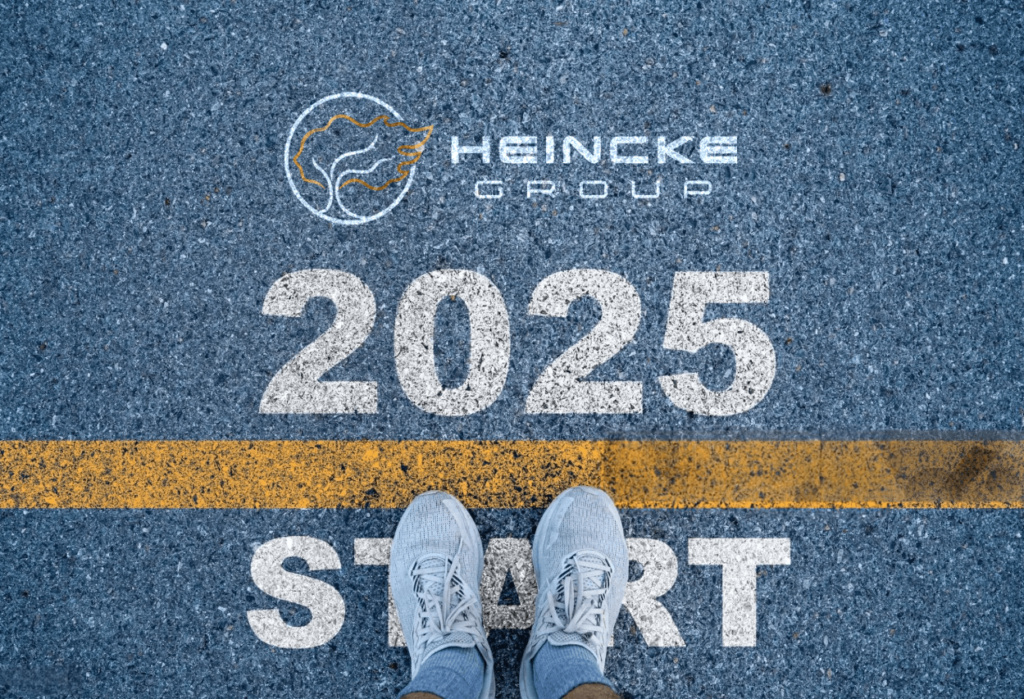 Imagen de unos pies justo frente a una línea de meta, con el logo de Heincke Group y el texto '2025' al fondo, simbolizando el inicio de un camino hacia el cumplimiento de metas y propósitos.