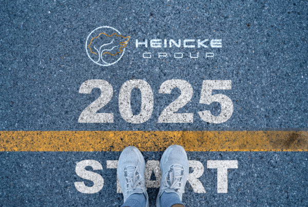 Imagen de unos pies justo frente a una línea de meta, con el logo de Heincke Group y el texto '2025' al fondo, simbolizando el inicio de un camino hacia el cumplimiento de metas y propósitos.
